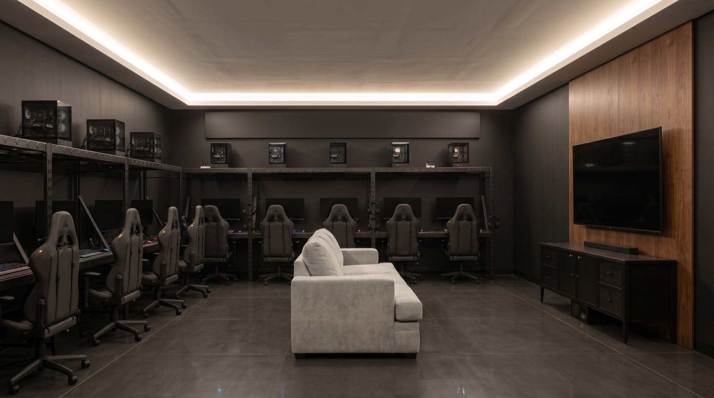 LK Amenities lounge — modern gaming amenity with curved cove lighting, race-style chairs, lounge sofa, and wall-mounted TV